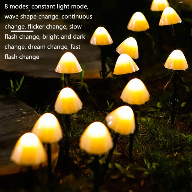 Warm white solar mushroom lawn lights glowing across grass with multiple bulbs