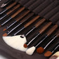 Row of makeup brushes with brown handles and black ferrules arranged in a dark case