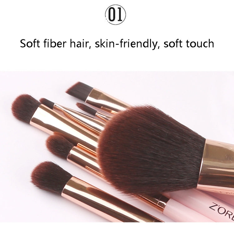 Pink-handled makeup brushes with dense brown bristles and gold ferrules