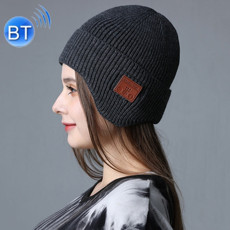Dark gray knit Bluetooth music hat with brown control patch, side view on model