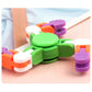 Close-up green plastic finger spinner toy with orange, purple, and white chain blocks