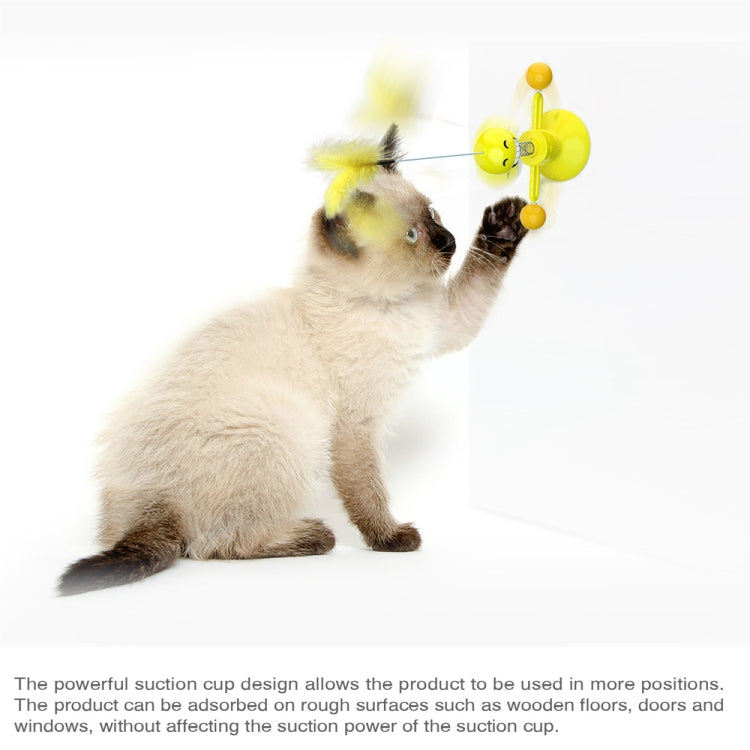 Cat playing with interactive feather spring ball toy on yellow suction cup base