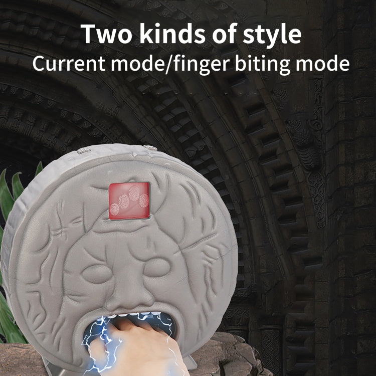Gray brain-shaped electric bite toy with red LED display on top and open mouth.
