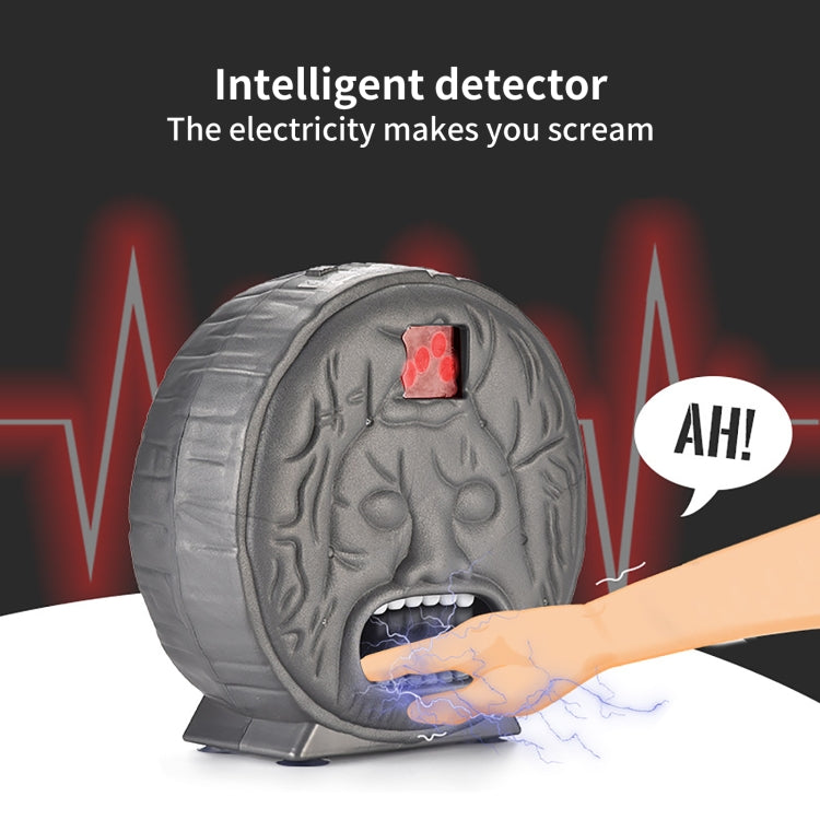 Gray brain-shaped electronic prank toy with red LED sensor and finger contact sparks.