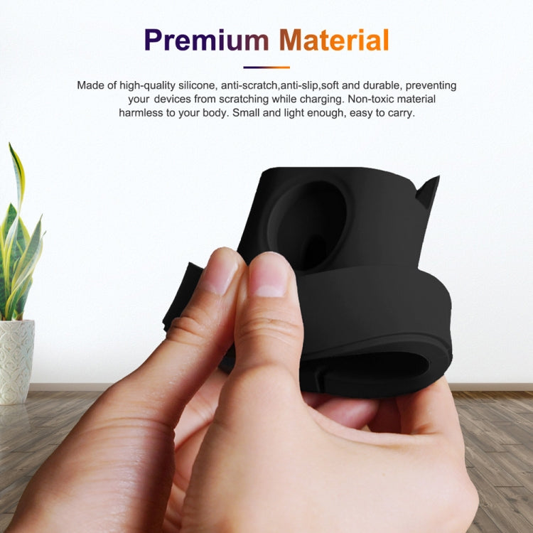 Black silicone watch charging stand held in hands with circular magnetic holder