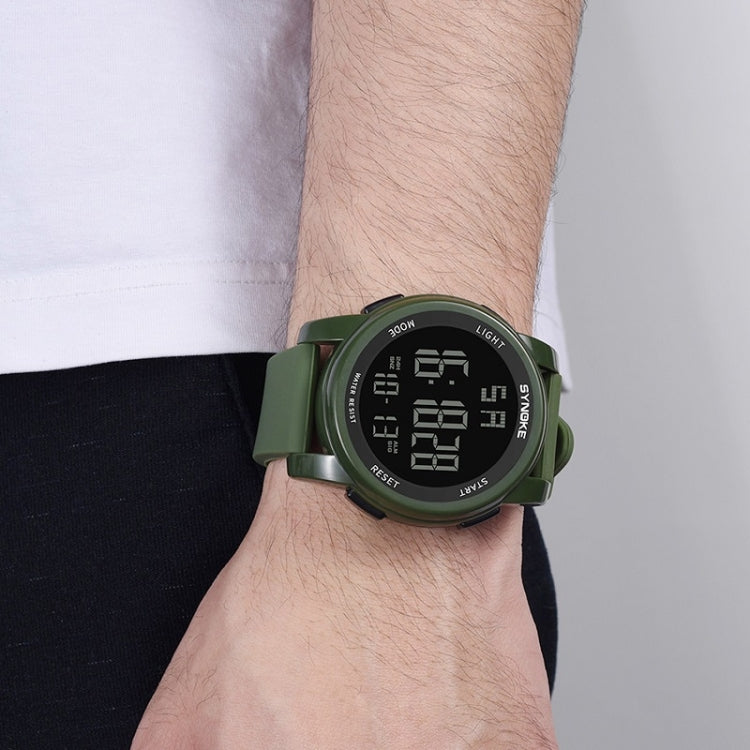 Army green digital sports watch worn on wrist with glowing LCD display