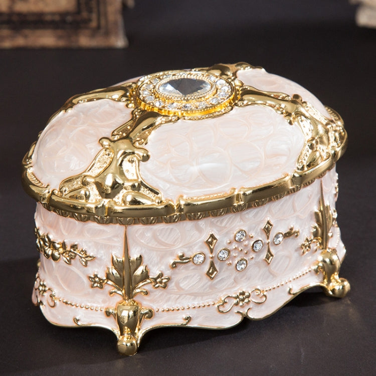 Gold-trim white oval jewelry storage box with diamond-style top and ornate side charms