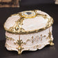 Gold-trim white oval jewelry storage box with diamond-style top and decorative bead details