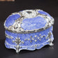 Silver-trim blue oval jewelry storage box with diamond-look bezel and embossed pattern lid