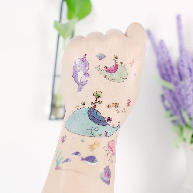 Marine animal tattoo stickers on arm with a whale, snail, and small sea creatures