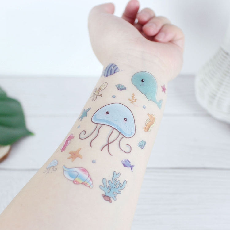 Marine animal tattoo stickers on arm with a blue whale, jellyfish, and starfish