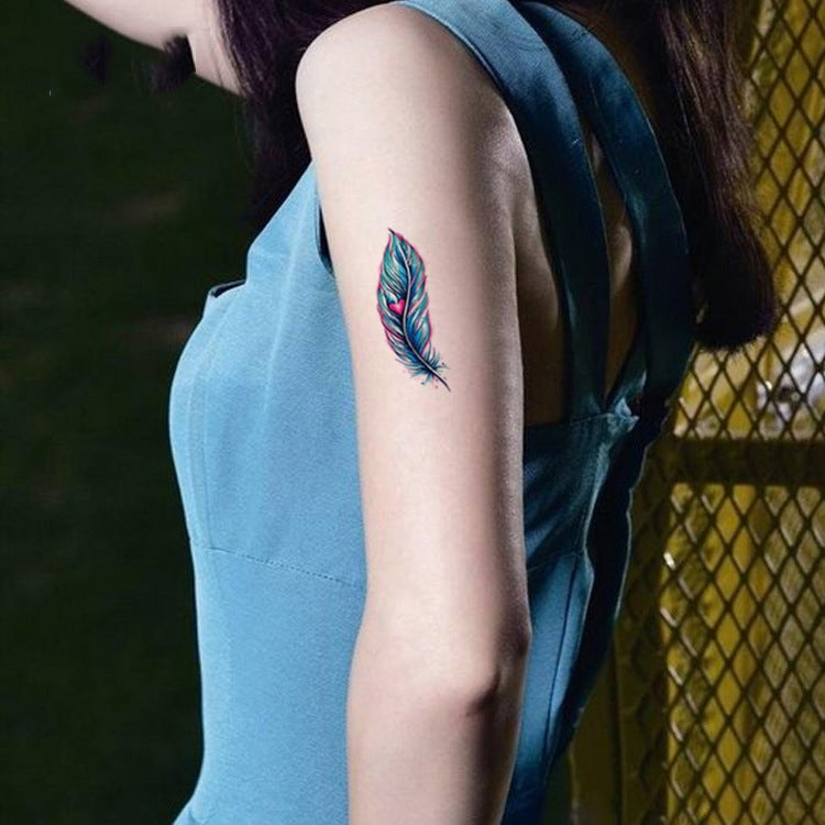 Single blue-green feather temporary tattoo sticker on upper arm