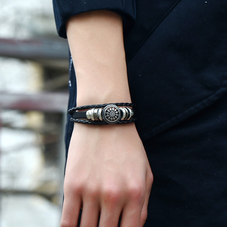 On-wrist view: black braided leather adjustable bracelet with round silver floral centerpiece