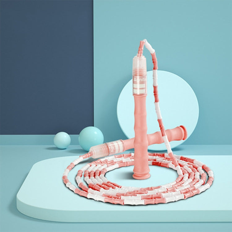 Pink and white bamboo-style PVC skipping rope, coiled with hand grips