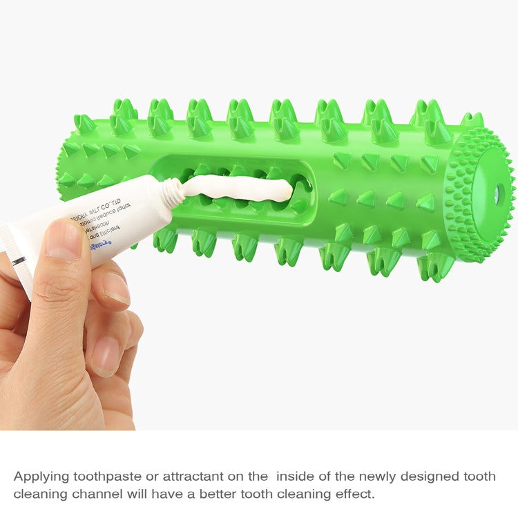 Hand applying toothpaste to the inside of a green spiked dog dental chew toy