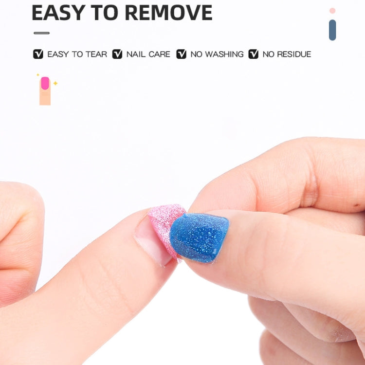Hand placing a blue glitter nail sticker onto a fingertip