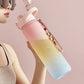 Cherry pink to sky blue gradient sports water bottle held at an angle with flip spout