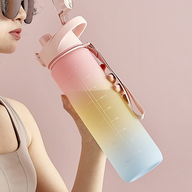 Cherry pink to sky blue gradient sports water bottle held at an angle with flip spout