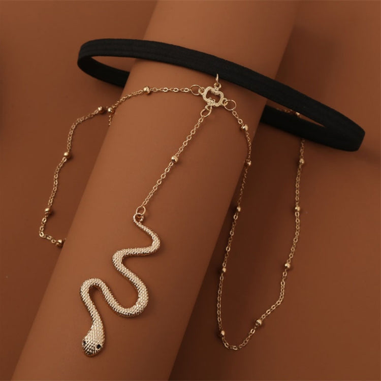 Gold-tone snake body chain with elastic black band and dangling snake charm