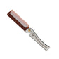 Folding beard styling comb with amber-brown handle, metal blade, and fine teeth