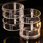 Transparent 4-tier jewelry box showing stacked clear rings and top lid