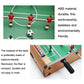 Close-up of foosball player figures and green playing field on a mini wooden table