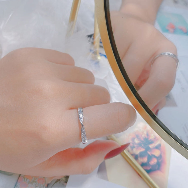 Silver open adjustable twist ring on a finger