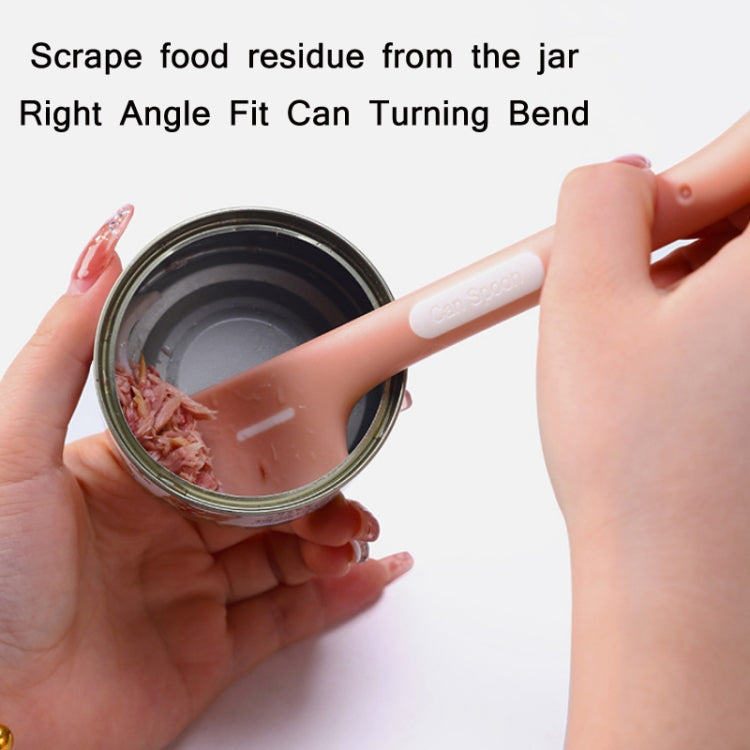 Pink long-handled cat-shaped spoon scooping wet pet food from a can jar.