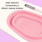 Pink silicone makeup brush cleaning pad with textured scrub ridges and resting brush.