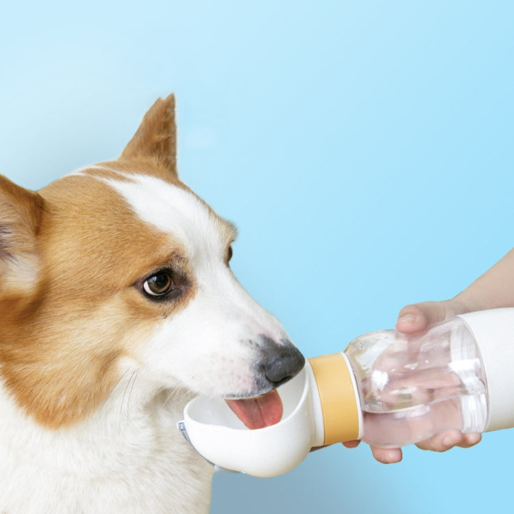 Portable pet water bottle with flip drinking cup as a dog drinks