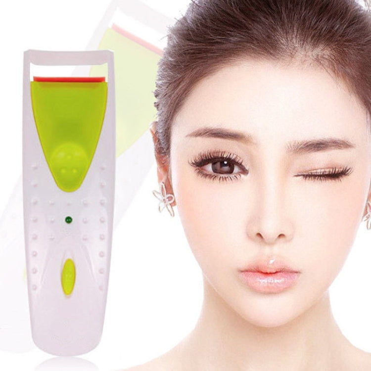 Electric heated eyelash curler with green silicone strip beside a close-up eye