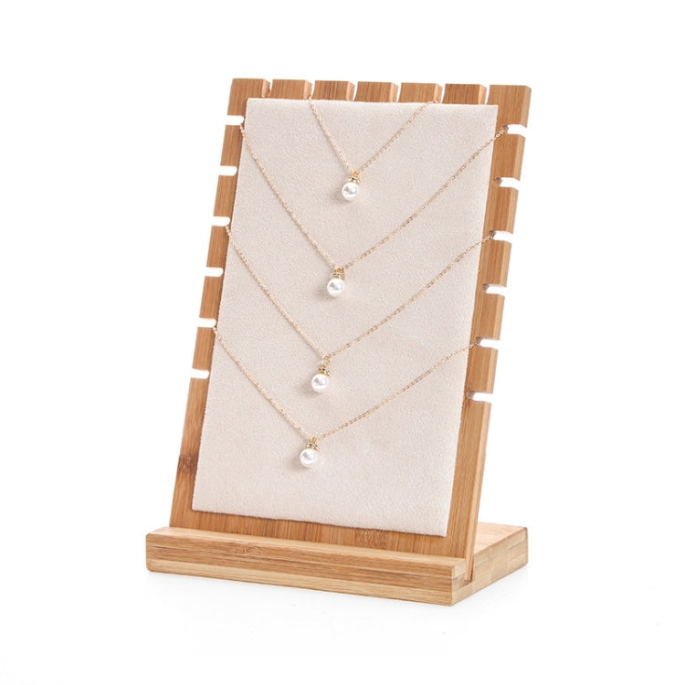 Bamboo jewelry storage stand with white felt panel and five pearl necklaces on hooks