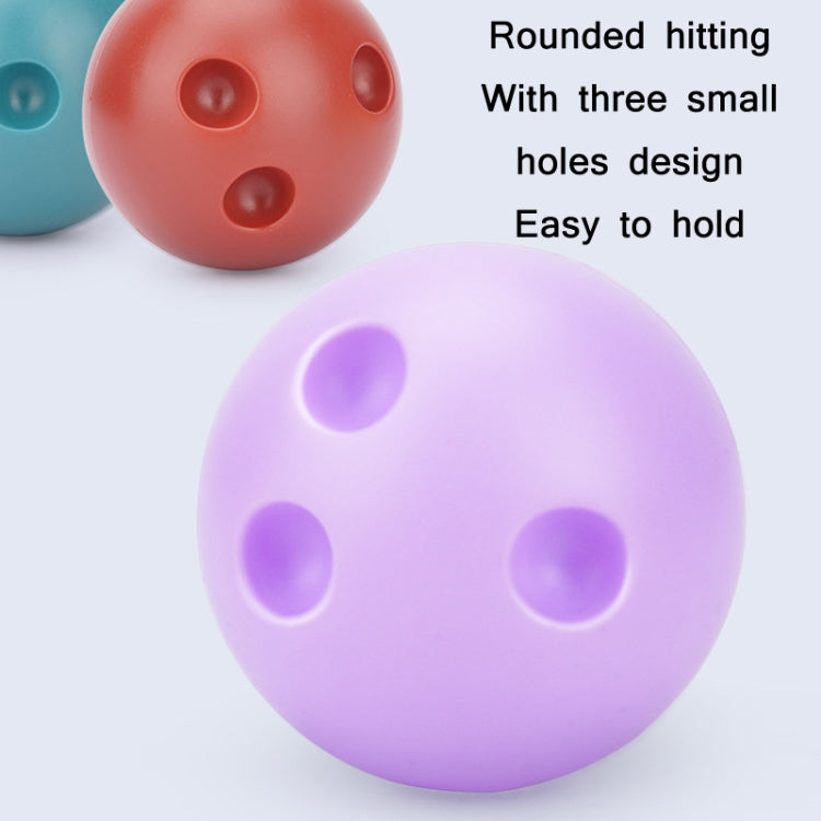 Purple plastic bowling ball with three finger holes, with red ball partially visible