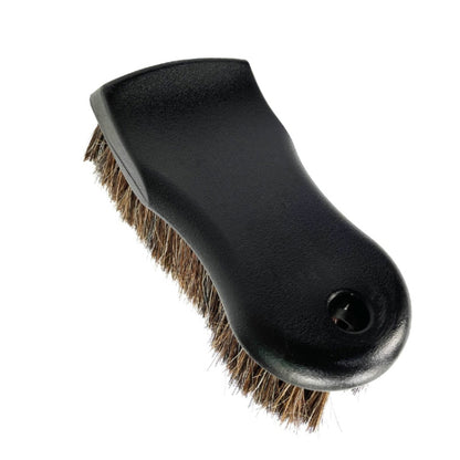 Black leather brush with horsehair bristles and round hole in handle