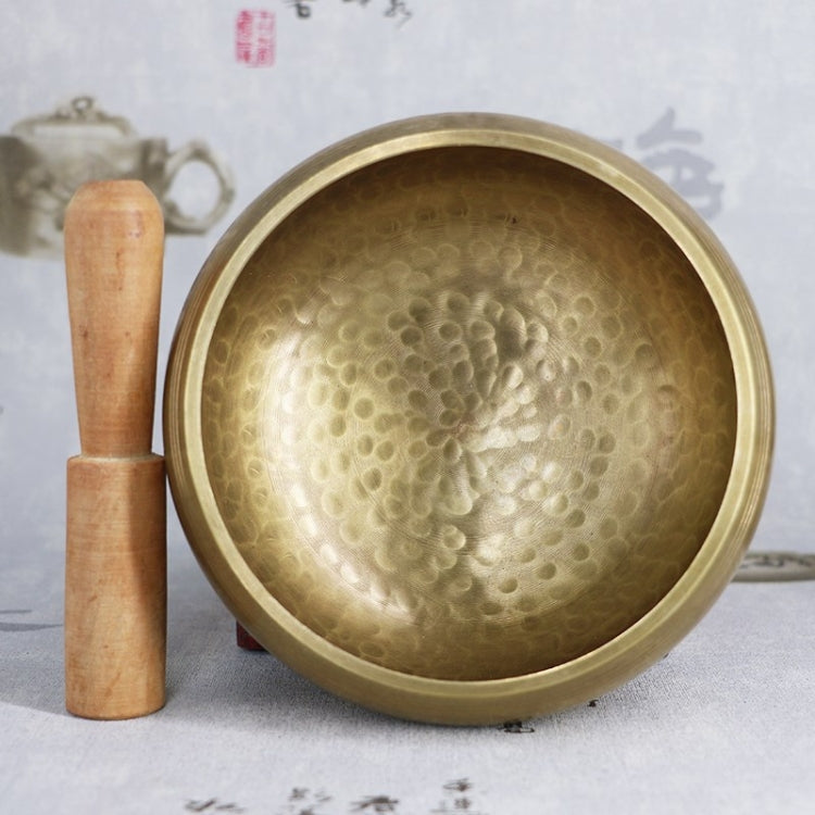 Buddha metal sound bowl top view with wooden mallet beside it