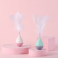 Set of two feather tumbler cat toys with white feathers, teal and pink bases