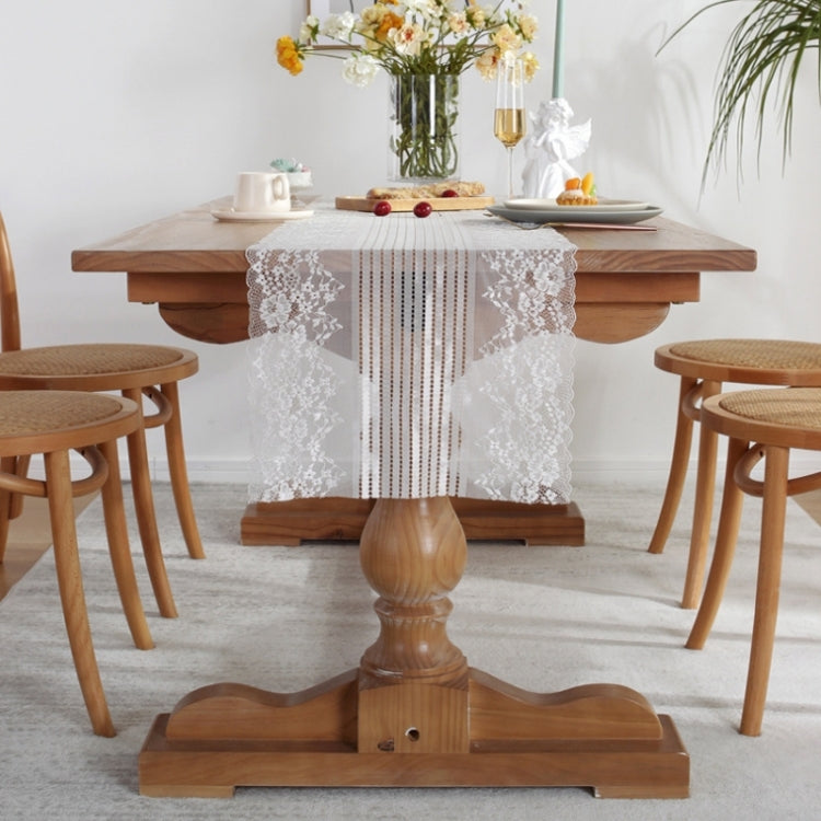White lace table runner centered on dining table, scalloped floral lace with striped middle