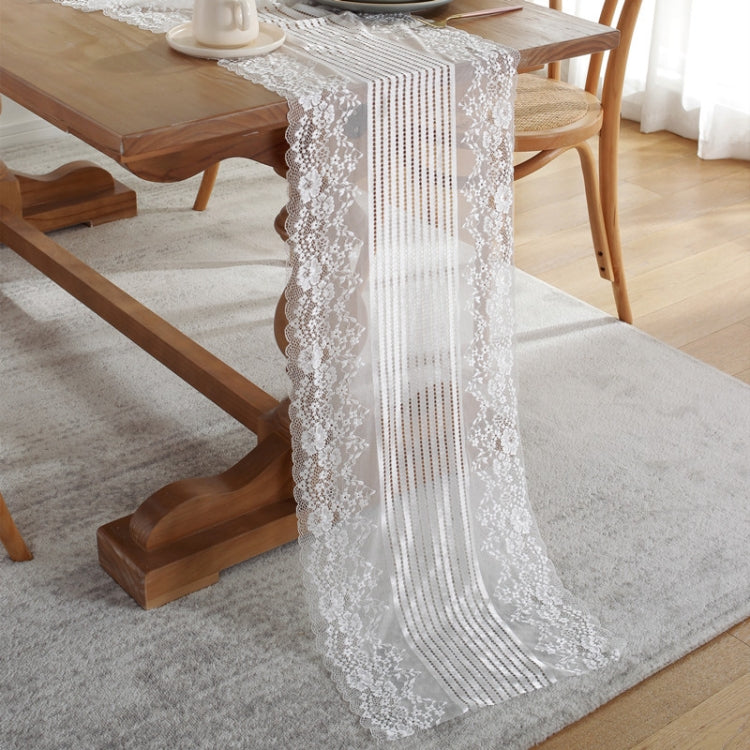 White lace table runner with scalloped edges and vertical striped center panel