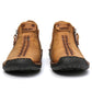 Pair of men's tan leather ankle boots with lace-up tabs and black outsole tread