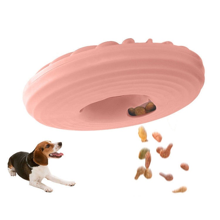 Pink round dog food puzzle toy with ridged surface and visible kibble pocket