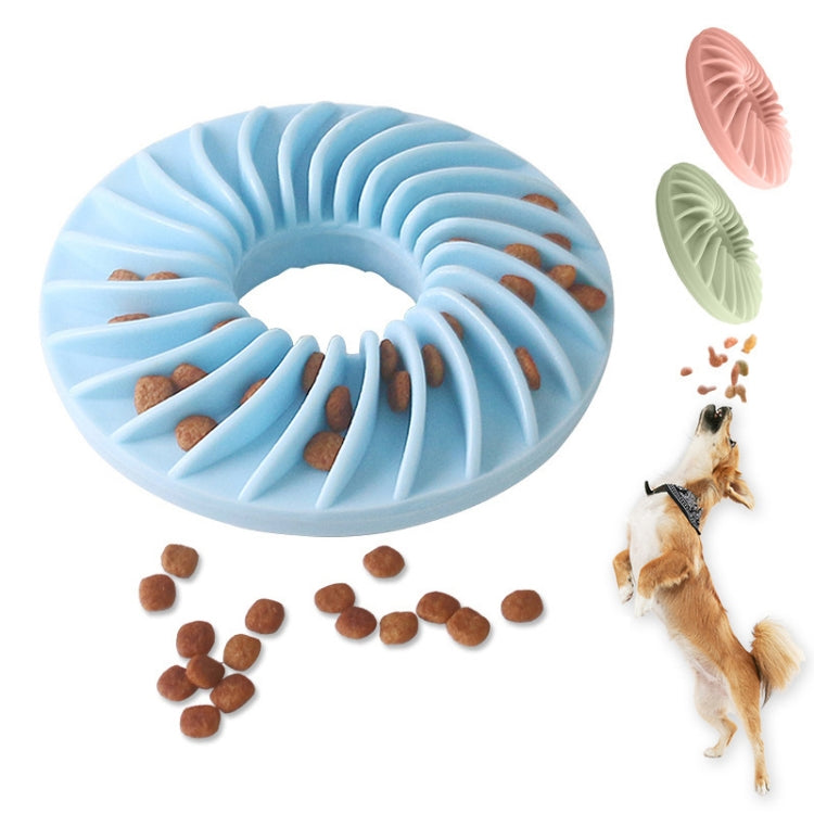 Blue round dog food puzzle toy with ridged channels and scattered kibble pieces