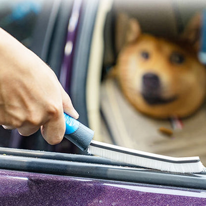 Car crevice cleaning brush with blue handle, used on car door track corner
