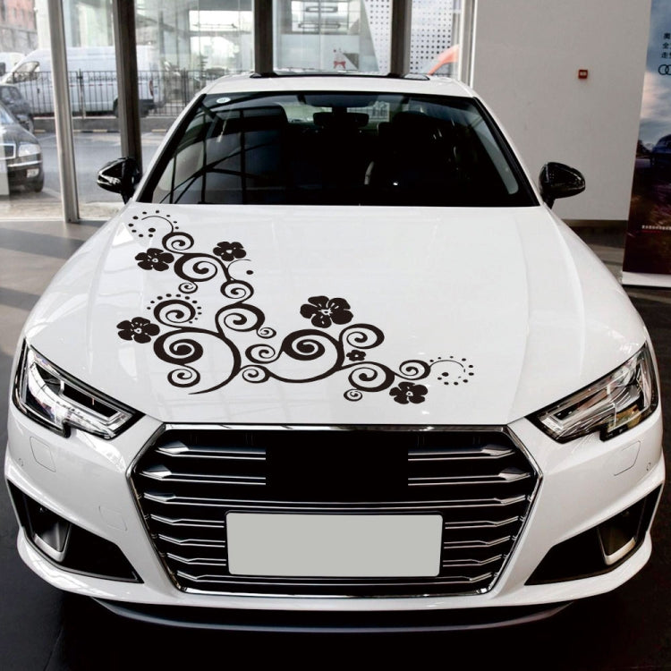 Black floral totem car hood sticker on white car with curled vines and flower icons.