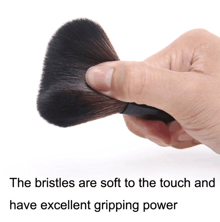 Makeup powder brush with soft dark bristles, held in a hand at the brush head