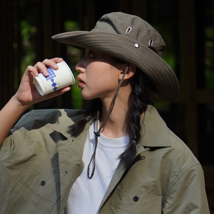 Khaki breathable drawstring fisherman hat worn by a person drinking from a cup