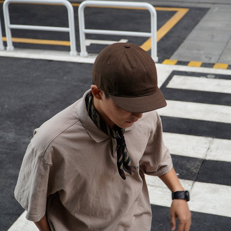Low-profile peaked cap in dark brown with short curved brim