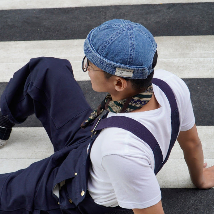 Denim blue denim melon cap on person, short brim and curved crown stitching