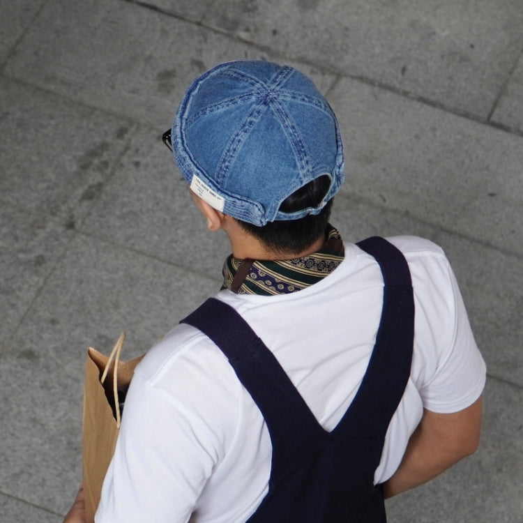 Denim blue denim cap viewed from behind with label patch and short brim