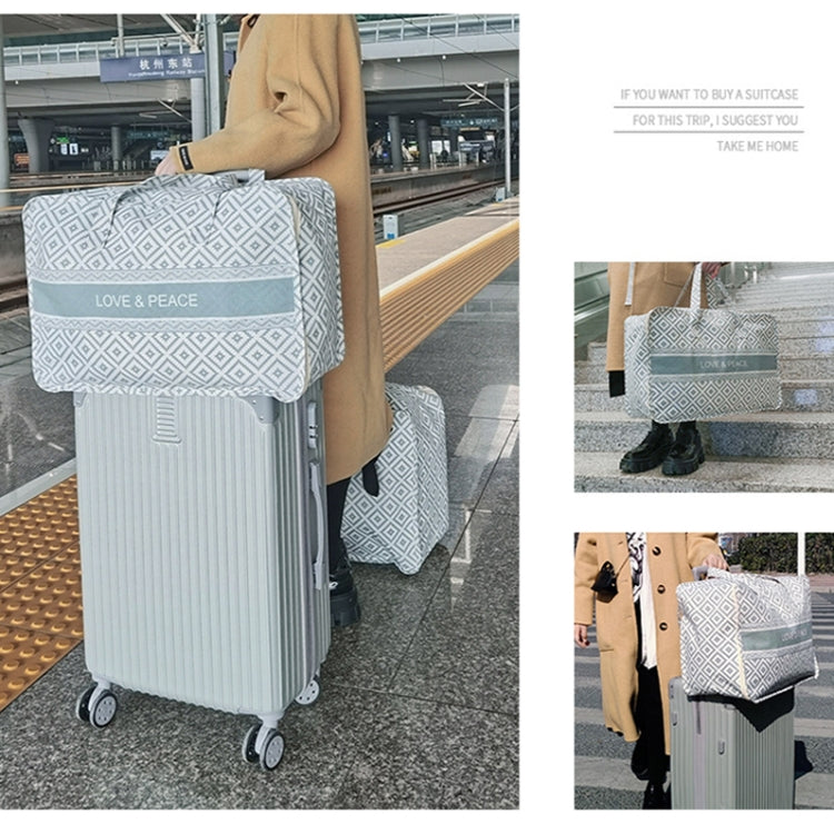 Gray-and-white geometric clothes organizer bag attached to a wheeled suitcase