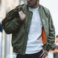 Green bomber jacket with zip front and visible orange lining panel; ribbed collar and hem
